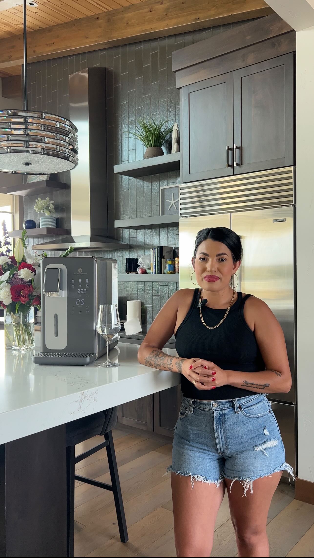 Woman standing beside Hydrogen water Hydra Luxe machine